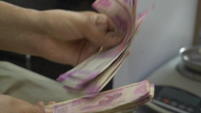 Closeup shot of hands counting 2000 Indian rupee banknotes, Cash in hand, Lots of cash