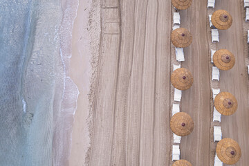 Drone view of beach straw umbrellas on an empty beach, Sicily, Mediterranean Sea, Italy