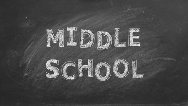 Hand drawing MIDDLE SCHOOL on black chalkboard. 
