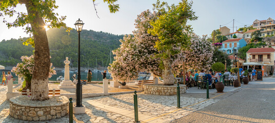 View of harbourside restaurant and colourful houses in Assos in golden hour, Assos, Kefalonia, Ionian Islands, Greek Islands