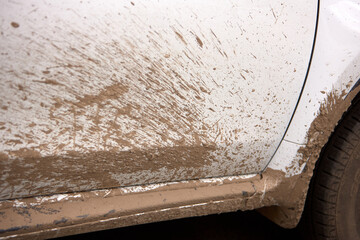 a dirty white car, splattered with mud.