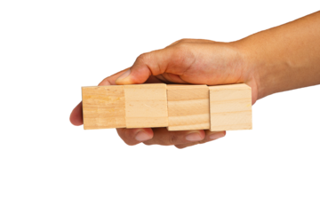 Close-up of hand holding four wooden cubes on a transparent background