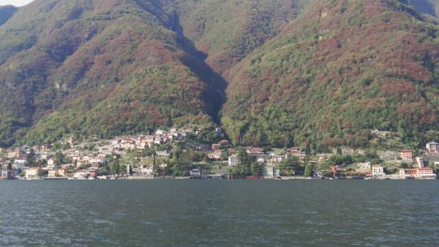 View of Laglio on Lake Como shore from ferryboat. A small lovely town with beautiful architecture.