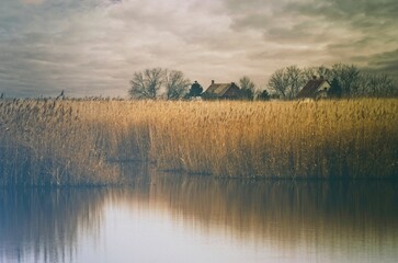 Autumn on the lake. Two houses and a reflection on the water.