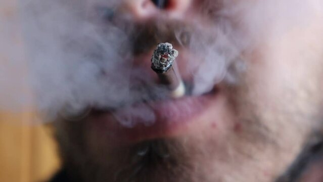 Close-up of a man's mouth smoking a cigarette and exhaling smoke. A bad habit - smoking. High quality video
