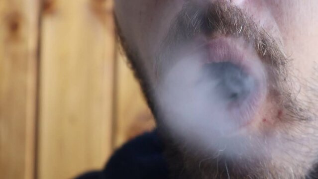 Man exhales smoke in rings after smoking a cigarette. A bad habit - smoking. High quality video