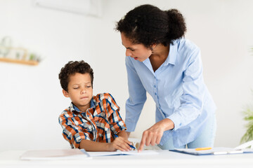 Angry Strict Teacher Lady Scolding Schoolboy Pointing At Copybook Indoors