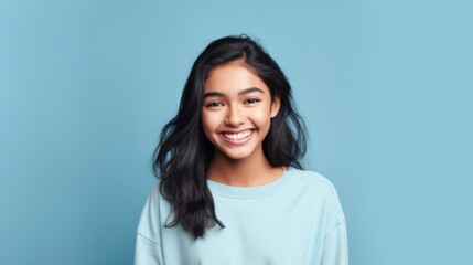 Fototapeta premium A cheerful young teen, her infectious smile lighting up the frame against a neutral studio setting.