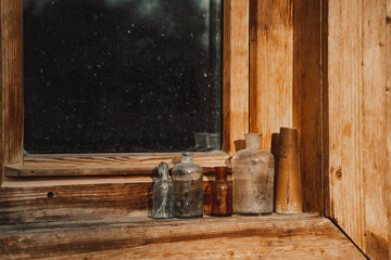several different old retro bottles on a wooden windowsill
