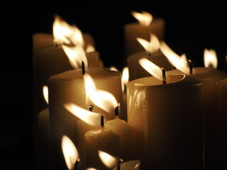 Flame of a candle on a grave. All Saints day. Votive candle on a dark black background. The Day of The Dead.