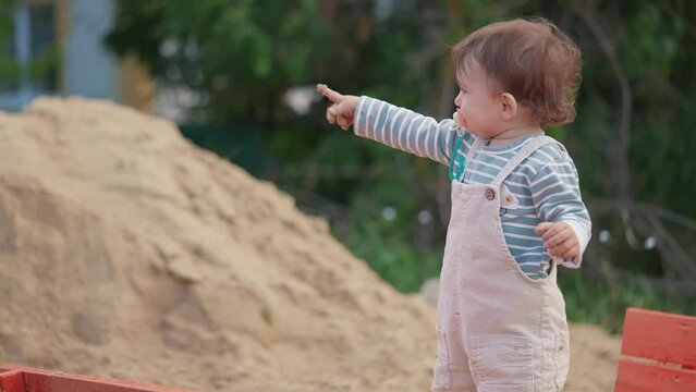 baby baby close-up in colorful sandbox. happy family kid dream concept. girl is playing on playground. baby sits in the sand playing with her toys. small child sits and lifestyle falls not hurt hit