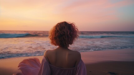 Fototapeta na wymiar curly-haired girl on the beach watching the sunset