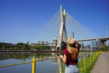 Visiting Sao Paulo, Brazil. Rear view of traveler woman looking at Ponte Estaiada bridge in Sao...