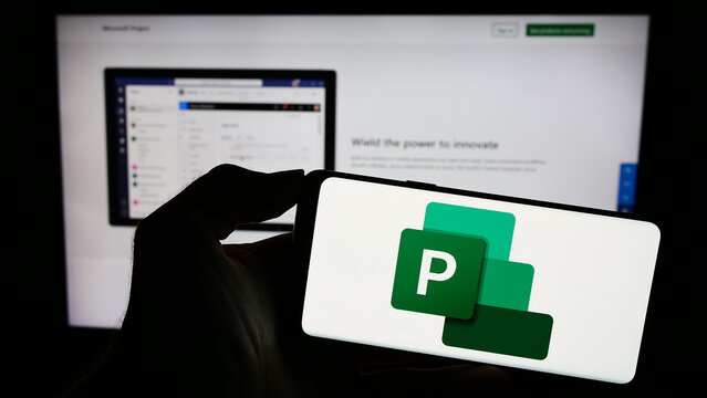 Stuttgart, Germany - 09-21-2023: Person holding mobile phone with logo of project management software Microsoft Project on screen in front of web page. Focus on phone display.