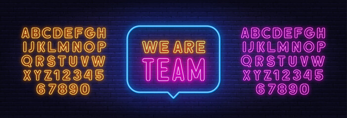 We Are Team neon sign in the speech bubble on brick wall background.