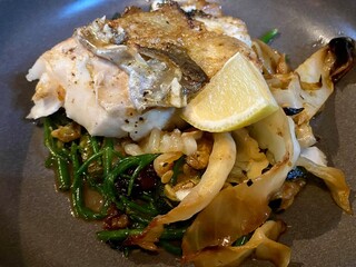 Pan fried cod fish with samphire and cabbage with lemon wedge 