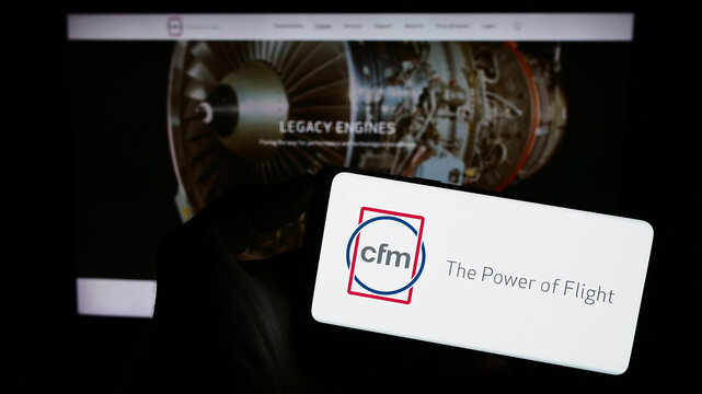 Stuttgart, Germany - 09-22-2023: Person holding cellphone with logo of aircraft engine company CFM International on screen in front of business webpage. Focus on phone display.