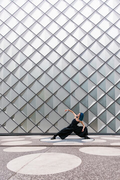 Dancer dancing in front of modern patterned wall