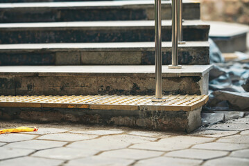 Yellow braille block on first step of stairs for blind handicap. Yellow tactile pavement for the visually impaired on the stairs.