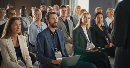 Back View Of Biopharma CEO Gesturing And Presenting To Audience of Diverse Industry Leaders. Male And Female Attendees Listening To Presentation About Biotechnology On International Medical Summit.