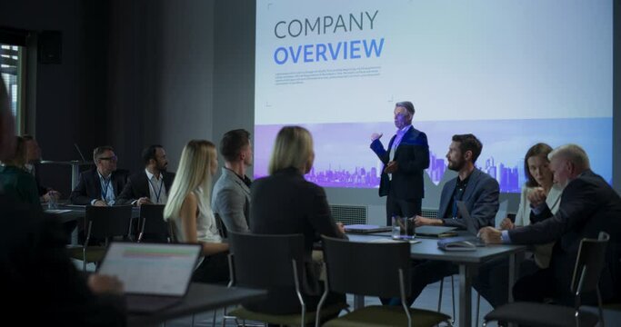 Corporate Event: Caucasian Male Tech CEO Giving Presentation To Colleagues, Investors In Conference Room Of Innovative Startup Company Office. Successful Man Talking About Business Vision And Mission.