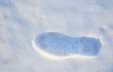 The footprint of a lonely man on fresh fluffy snow. The concept of coming winter.