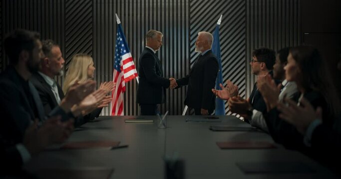 High-Level Political Forum: Two Caucasian Male Politicians From EU And United States Shaking Hands On Successful Deal. Diverse Delegates Applauding Successful International Agreement at Conference.