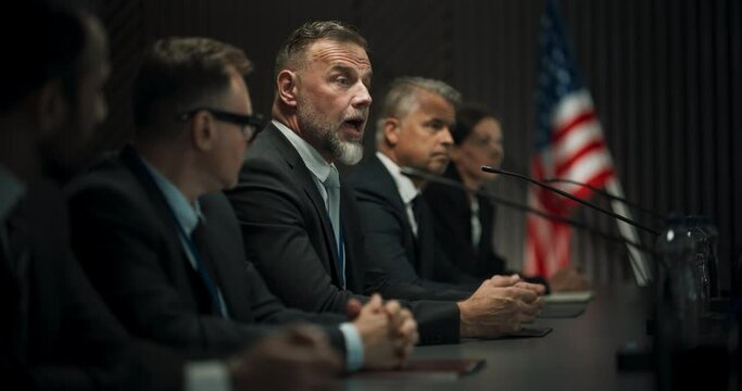 Caucasian Male Organization Representative Speaking at Economic Forum. Head Of USA Delegation Delivering Speech at International Political Summit Press Conference. Diverse Delegates Listening.