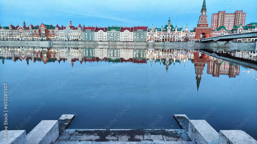 Wall mural Beautiful buildings on the embankment near the water on the Bruges embankment in Yoshkar-Ola. Cityscape and landscape in the evening