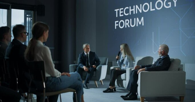 International Technology Conference: Male Host Asking Caucasian Female CEO a Question In Front Of Audience. Successful Woman Delivering Inspirational Speech And Diverse Attendees Applaudding Her.