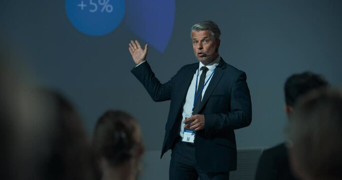 Corporate Event: Caucasian Male Tech CEO Giving Presentation To Colleagues or Investors In Conference Room Of Innovative Startup Office. Successful Man Talking About Business Vision And Mission.