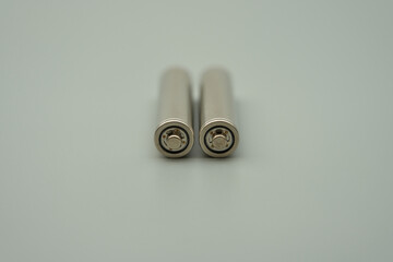 The head of an AAA 1.2V rechargeable battery with the outer casing removed, gray background