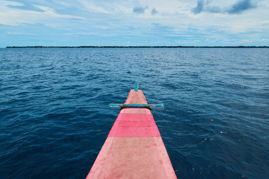 The prow of a Philippine banca boat with a view of Olango Island in the distance, along with the sky and the horizon