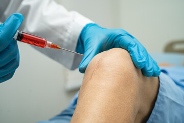 Asian doctor inject Hyaluronic acid platelet rich plasma into the knee of senior woman to walk without pain. - obrazy, fototapety, plakaty