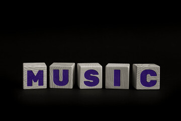 Word MUSIC written with wooden cubes. Studio shot of some arranged wooden blocks with a textual message.