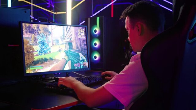Gamer playing the newly released internet computer action simulator. Gamer playing the round of an online computer game. Gamer playing with a heavy rifle in the multiplayer computer simulator.