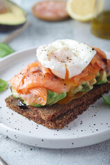 A rye bread sandwich with avocado and salmon	
