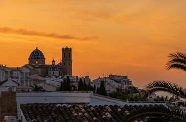 Sunrise with golden sky over the city of Altea with catholic church in the middle colled Nostra Senyora del Consol
