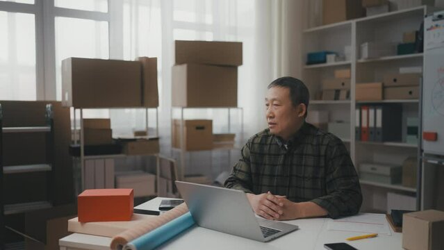 Senior Asian man entrepreneur sitting upset in his office, unprofitable business