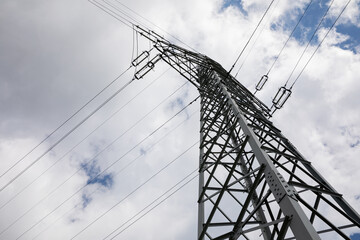 View from below of the tall poles of the high-voltage overhead line.