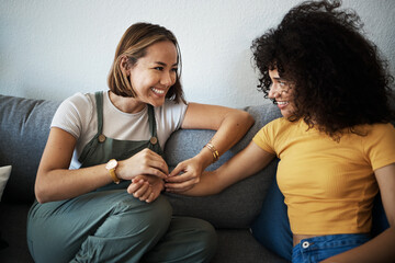 Conversation, happy and lesbian couple relaxing on a sofa in the living room talking and bonding....