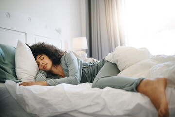 Woman, peace and sleeping on bed in bedroom with fatigue and burnout, dream and relax for stress relief. Exhausted, person and girl in house or home lying on pillow in apartment for wellness and calm - Powered by Adobe