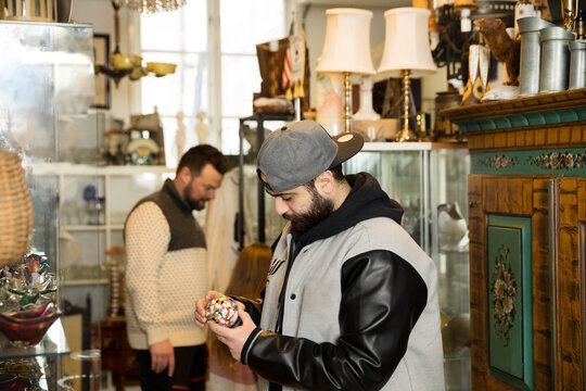 Man checking trinket in antique shop