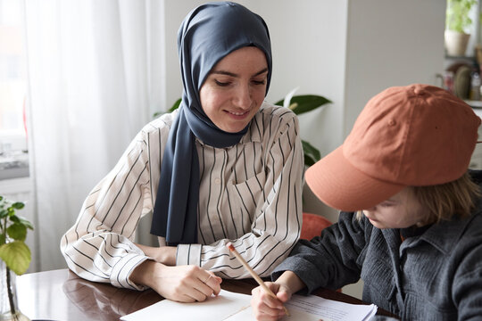 Mother helping son with homework at home