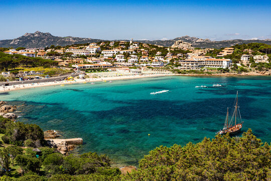 Summer, Cliff Top View Looking Down on the Picturesque Beach of Cala Batistoni and Baia Sardinia Village with Sea Front Shops and Villas.