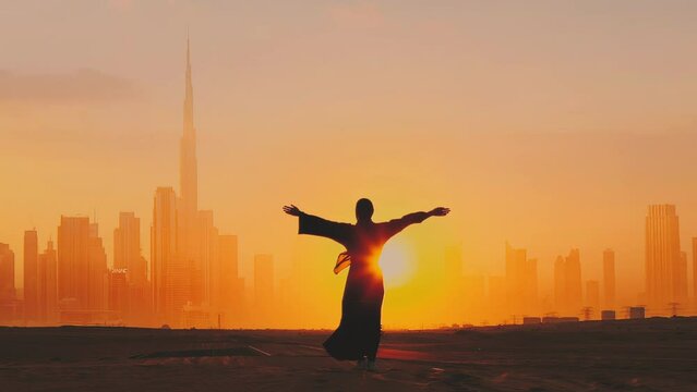 Arab woman rises her hands on Dubai city silhouette with sunset
