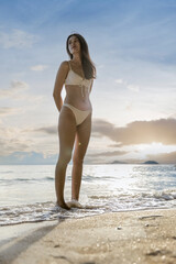 Woman on beach and sand during summer vacation. Beautiful girl on sun tanning in a tropical beach. Female tourist in bikini on sandy beach. Sexy bikini body woman on paradise tropical beach
