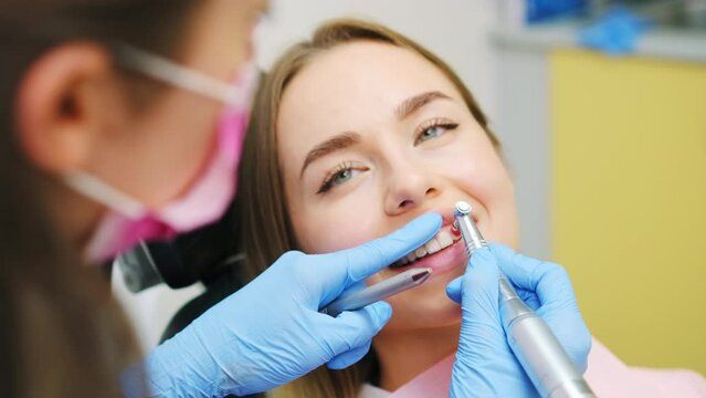 Dentist doing procedure of teeth grinding in dental clinic. Woman visits dentist practitioner creating perfect smiles by grinding procedures