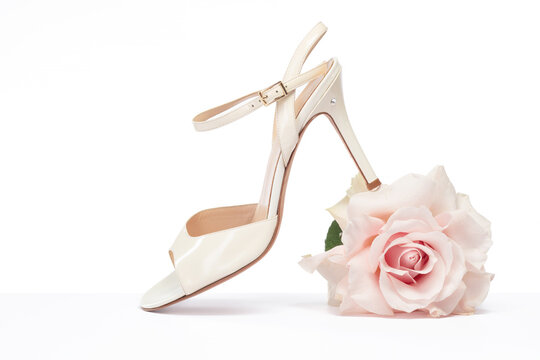 Female tango shoe with a rose on a white background. Argentine tango shoes with a rose. Selective focus