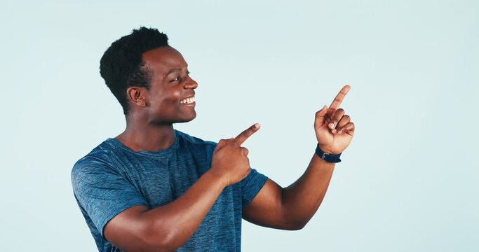 Man, smile and pointing in studio on blue backdrop with face for presentation, product placement or offer. Black, person or consumer with laugh, excited and happy for news of sale, discount or online